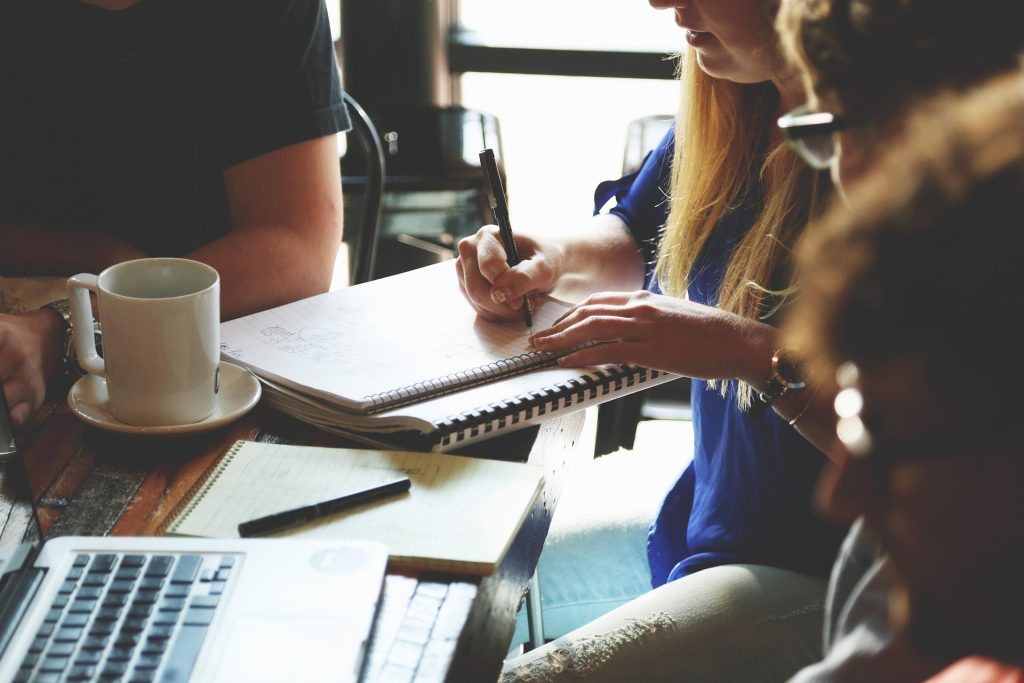 Team im Meeting bespricht, ob sich externe Unterstützung für Unternehmenstexte lohnt
